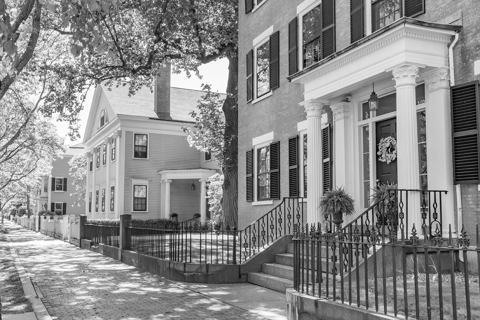 Colonial homes on a brick sidewalk street in Massachusetts